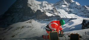 Technician setting up seismic station in the mountains