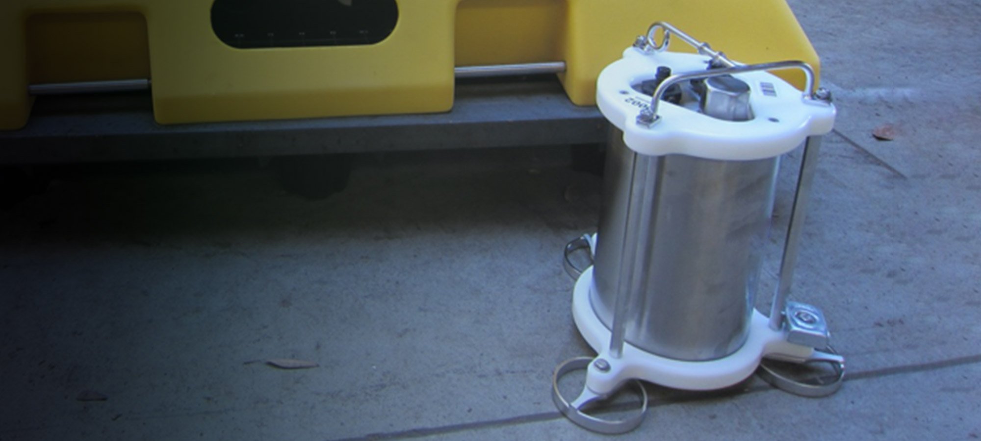 Stainless steel Trillium Compact OBS seismometer sitting on the deck of a ship beside an Abalones