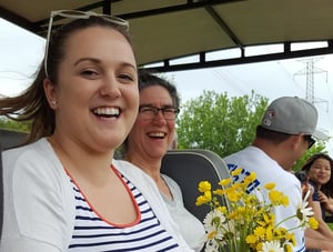 Nanometrics staff members holding flowers sitting outdoors