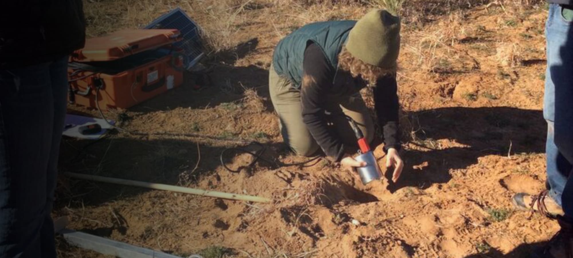 Katherine Aur, Staff Scientist, IRIS PASSCAL burying a seismometer in the sandy soil