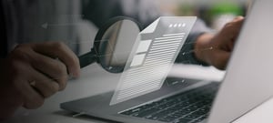 Man with magnifying glass reading virtual document