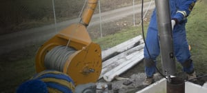 Winch lowering a seismometer into a borehole.