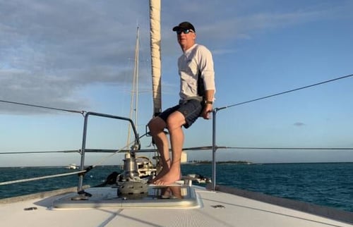 Former CEO Neil Spriggs relaxing on the railing of a sailboat out on the water