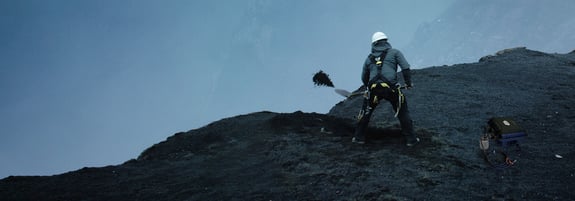 Scientist burying a sensor on the top of a mountain
